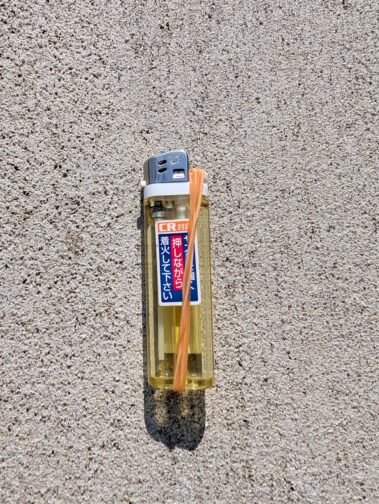輪ゴムを使ってライターのガス抜きをしているところ