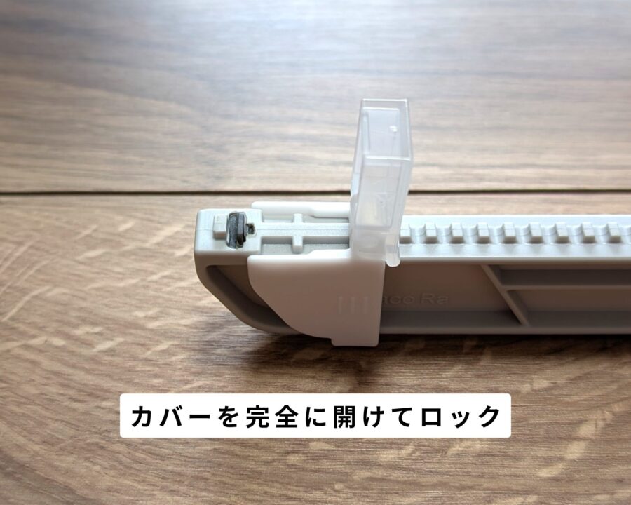 ダンボールサイズ調整カッターのカバー部を拡大した写真。カバーを完全に開けてロックしている。