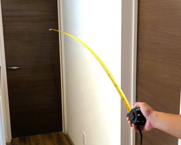 コンベックスのテープを延ばしているところの写真。2mほど出しても折れ曲がることなく伸ばすことができる状況を説明している。