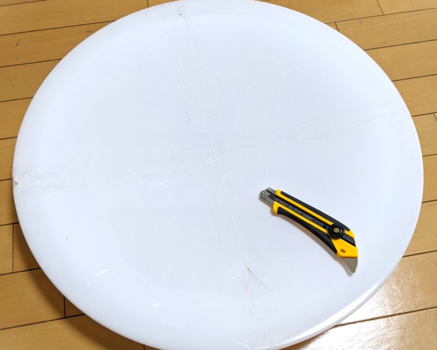 カッターでカバーに傷をつけている様子。テープをなぞるように傷をつけている。