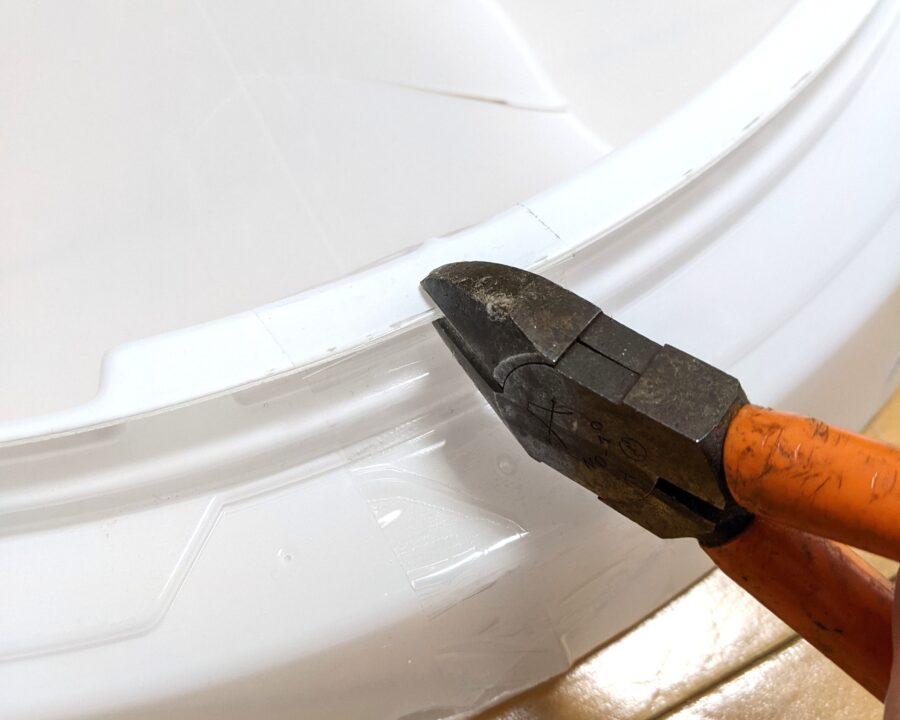 照明カバーにニッパーを当てているところの写真。