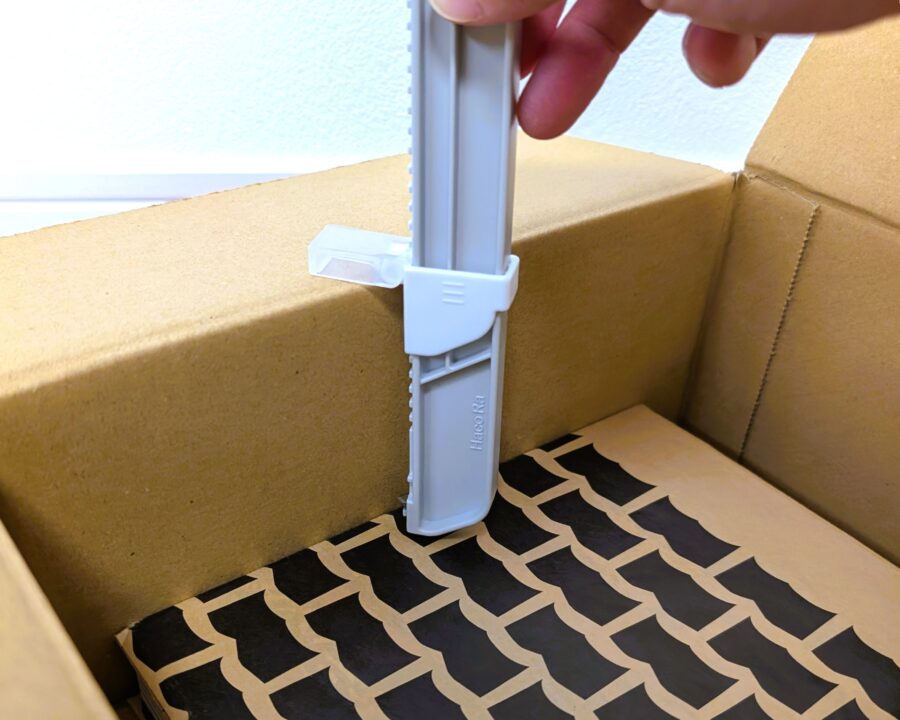 ダンボールサイズ調整カッターを使っているところの写真。高さを調整している。