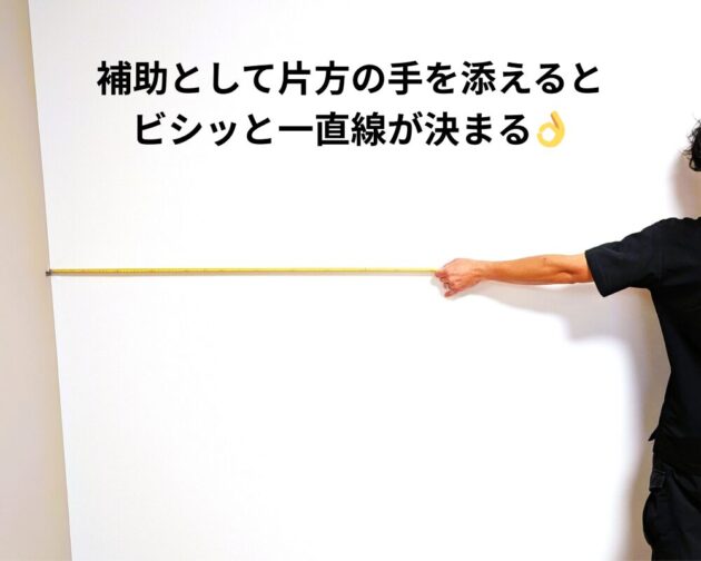 片手を添えてテープが一直線に延びている。