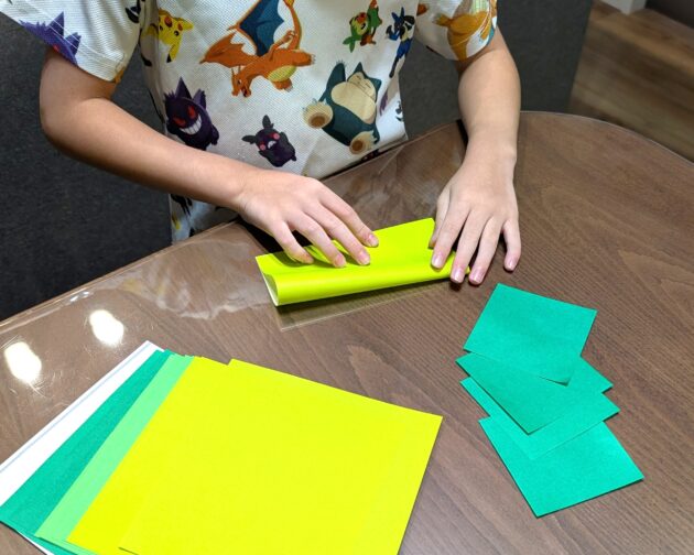 子どもがおりがみを折っている